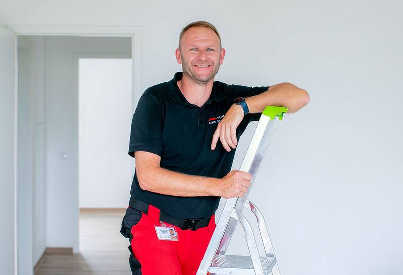 Vermieter übergibt einer jungen Frau die leere Wohnung